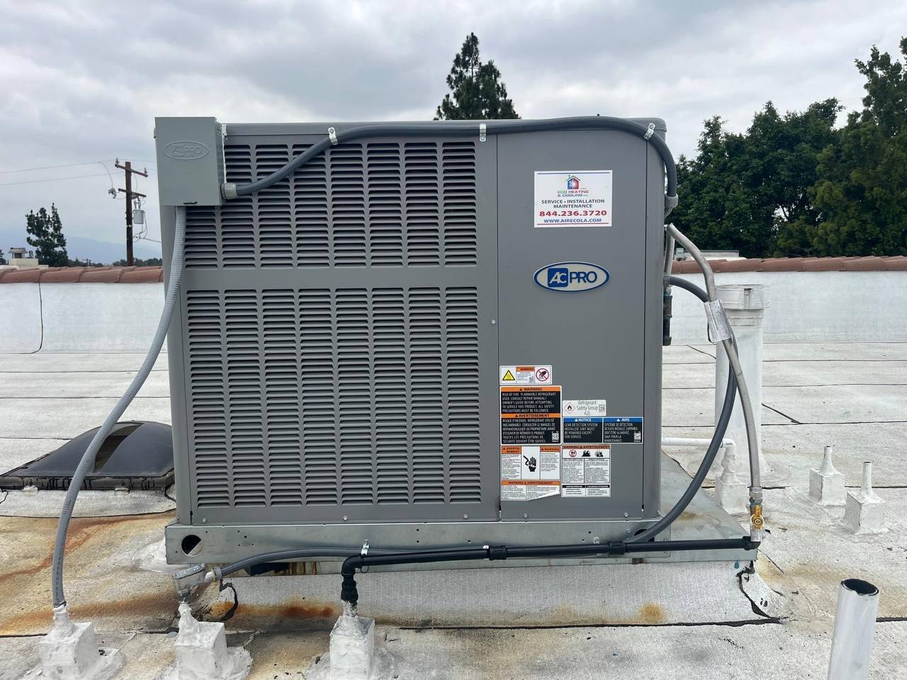ECO Heating & Cooling commercial rooftop AC unit installation — AC Pro package unit with ECO service sticker